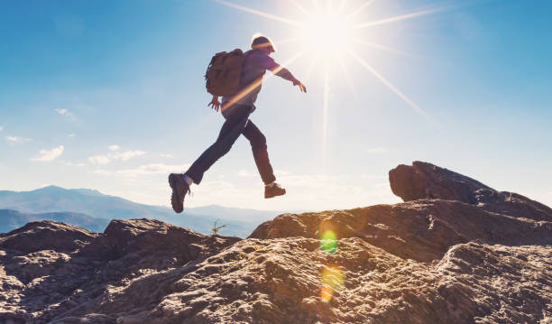 istock Man jumping over gap on mountain hike 1143165306