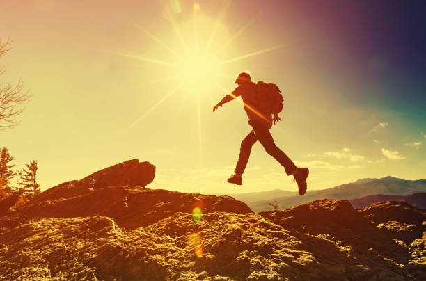 istock Man jumping over gap on mountain hike 1143165308
