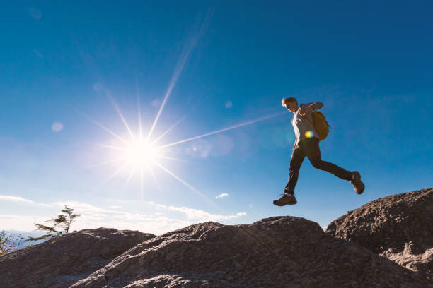 istock Man jumping over gap on mountain hike 1143165316