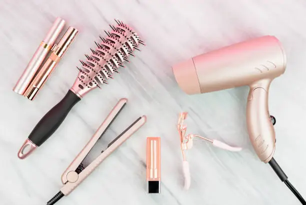 Photo of Women’s styling tools and cosmetics in rose gold