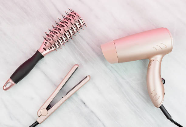 las herramientas para el peinado de las mujeres en oro rosa - straightener fotografías e imágenes de stock