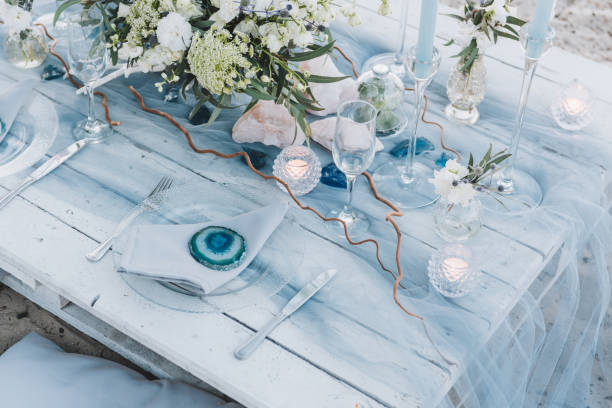 elegante configuración de mesa en tonos pastel azules para una boda en la playa - boda playa fotografías e imágenes de stock