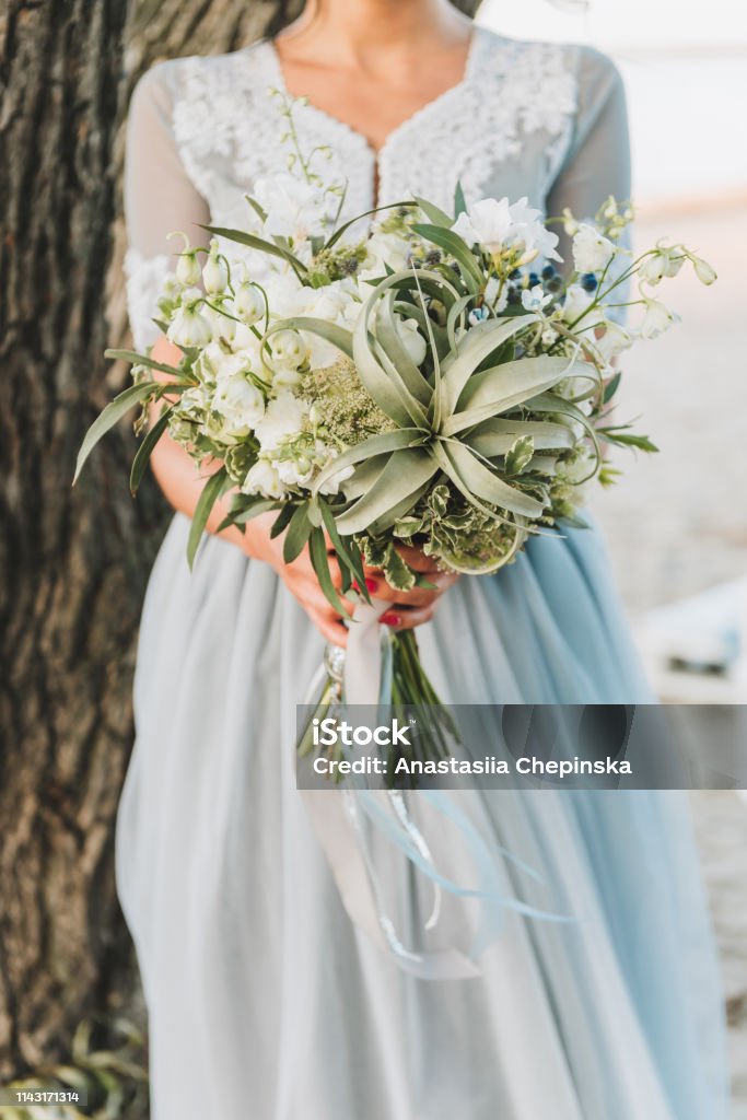 Conveniente región Capilares Novia Vistiendo Vestido De Boda Azul Claro Sosteniendo Ramo Foto de stock y más banco de imágenes de Aire libre - iStock Conveniente región Capilares Novia Vistiendo Vestido De Boda Azul Claro Sosteniendo Ramo Foto de stock y más banco de imágenes de Aire libre - iStock