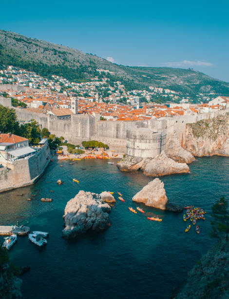 Dubrovnik walls, kayaks sailing in ocean Dubrovnik abandoned basketball court dubrovnik walls stock pictures, royalty-free photos & images