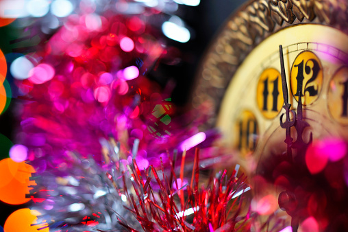 2023 New Year with fireworks and clock counting down to midnight with defocused golden background