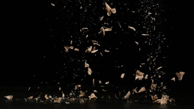 Wood Chips Falling against Black Background, Slow Motion 4K