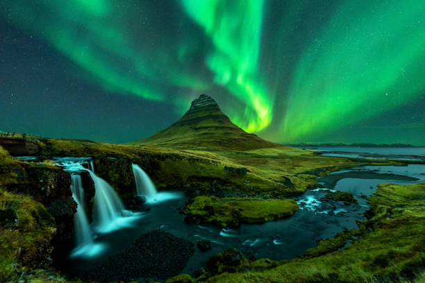 les aurores boréales apparaissent au-dessus du mont kirkjufell avec la cascade de kirkjufellfoss en islande. - aurore boréale photos et images de collection