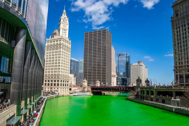 chicago river dyed green for st. patty's day as crowds gather to party and celebrate on a cold day - skyscraper travel people traveling traditional culture imagens e fotografias de stock