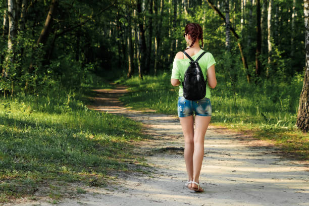 istock Girl walking in the park. spring Copy space 1143186334