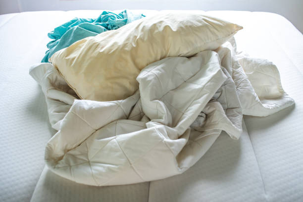 istock Turquoise and White crumpled bed sheet, Ivory pillow on white bed, Close up shot, Selective focus, Bedroom cleaning concept 1143186611