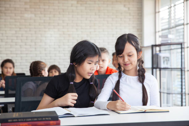 istock group of school kids clapping hands in classroom (education concept) 1143188417