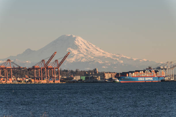 Seattle Seattle, USA - Mar 4, 2019: A Cosco shipping tanker on Elliott bay leaving port late in the day with Mount Rainier in the background. elliott bay photos stock pictures, royalty-free photos & images