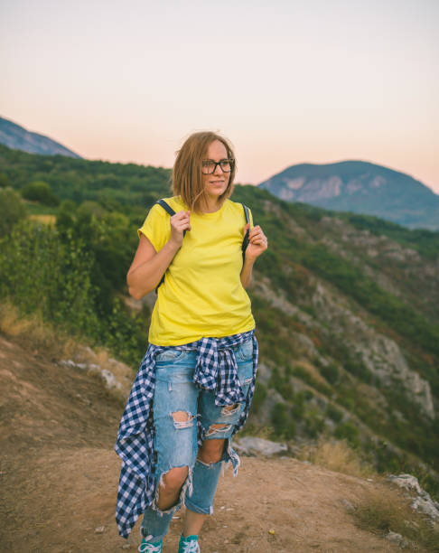 istock Pretty Young Woman looking off a cliff into valley 1143189766