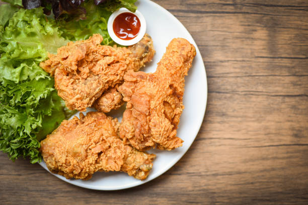 istock Fried chicken crispy on white plate with ketchup and salad lettuce vegetable on wooden background 1143199042