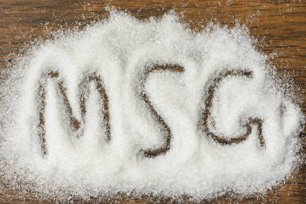 istock Heap of monosodium glutamate on wooden background with text MSG 1143199084