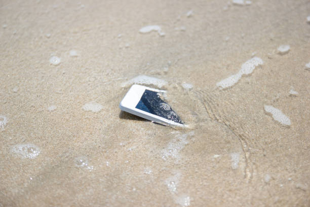 istock White Mobile phone floated to the sea at the beach. 1143199092