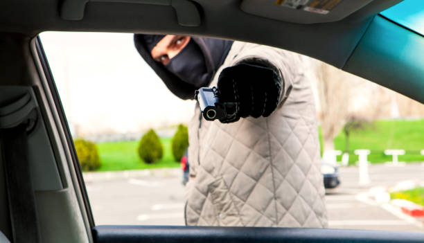 istock a thief with a gun threatens the driver 1143201287