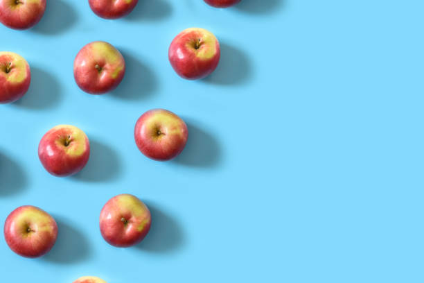 istock Juicy ripe red apples on a blue pastel background 1143205577