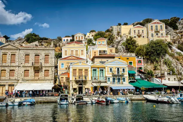Greek island with pastel colored houses under clear blue skies