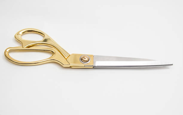 istock golden metal scissors for cutting lie on a white background 1143207082