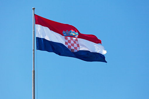 Croatian flag waving atop of its pole.