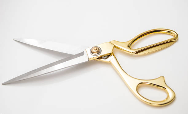 istock golden metal scissors for cutting lie on a white background 1143207342