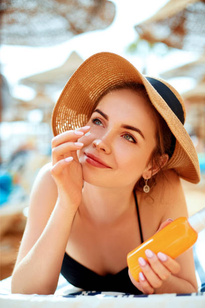 suntan lotion woman applying sunscreen solar cream. skincare - spray tan body human skin imagens e fotografias de stock