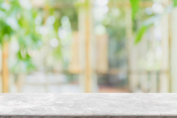 istock Empty white stone marble table top and blurred of interior room with window view green from tree garden background background - can used for display or montage your products. 1143209733