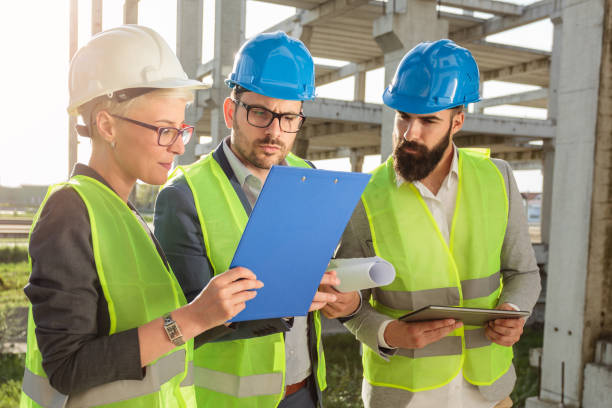 istock Small group of architects and civil engineers discussing future plans and looking at project documentation 1143211470