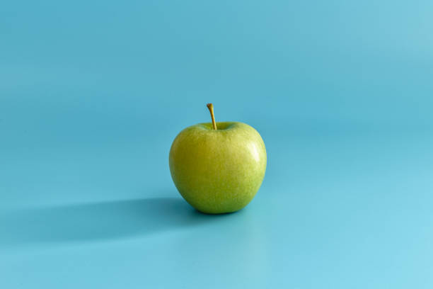 istock Juicy ripe green apple on a blue pastel background. 1143213833