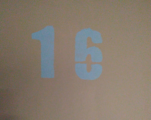 istock Number 16 painted with blue paint on a pink background. Symbol. Close-up. 1143213955
