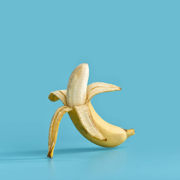 istock Juicy ripe yellow open banana levitates on a blue pastel background. 1143220137