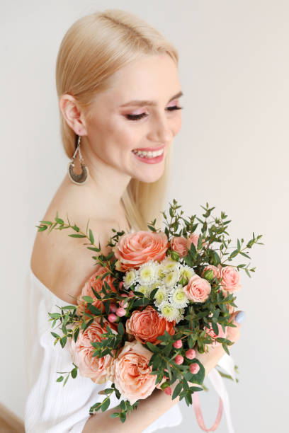 istock Attractive young woman posing over grey background with flowers. 1143221636