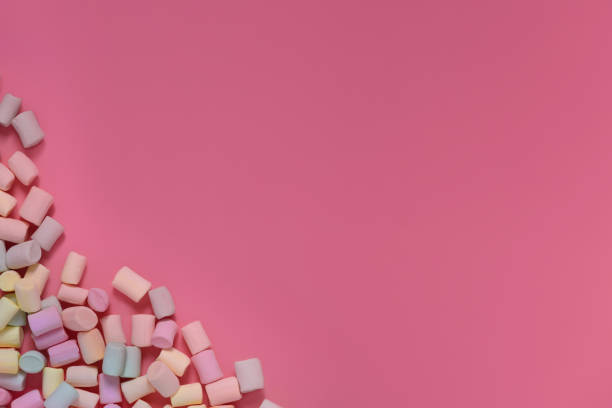 istock Isolated multicolored marshmallows scattered in the corner on a pink background. Banner, postcard. Top view, copy space. 1143222795