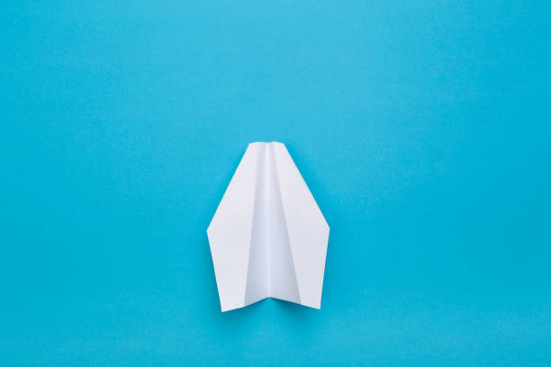 istock Flat lay of white paper planes on blue background with text space. - Image 1143224099