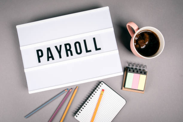Payroll. Text in light box Payroll. Text in light box. Pink coffee mug on gray background paycheck photos stock pictures, royalty-free photos & images