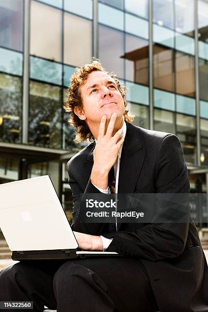 Hombre De Negocios Con Ordenador Portátil Pensamiento Foto de stock y más banco de imágenes de Adulto