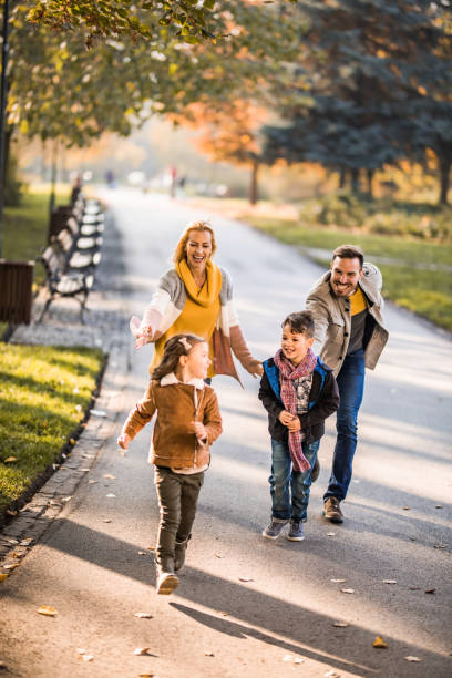 istock Playful siblings having fun while running away from their parents in the park. 1143229577