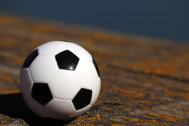 istock Soccer ball on wooden background 1143231403