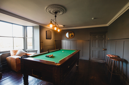 Wide angle view of an interior of a games room in a house.