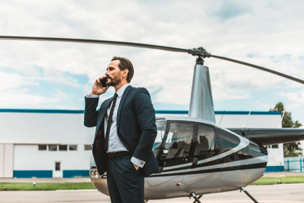 istock Calm man talking on the phone while standing near the helicopter 1143235050