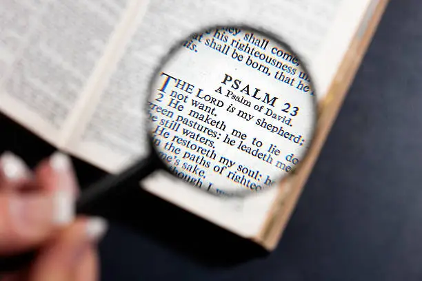 Psalm 23, "The Lord Is My Shepherd", seen through a magnifying glass held by a woman's hand. Camera: Canon EOS 1Ds Mark III.