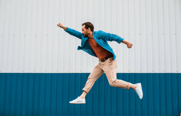 istock Young man having fun and jumping like superhero 1143235685
