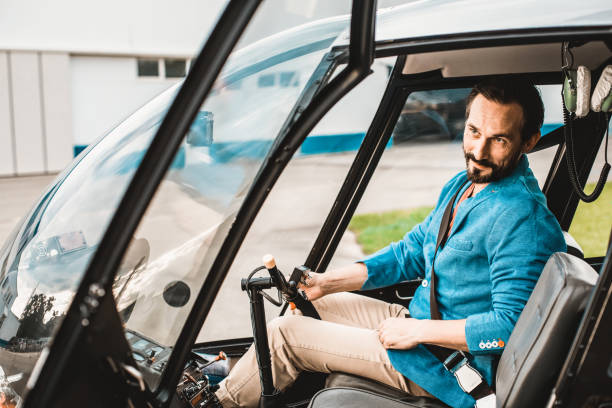 istock Relaxed man sitting in the helicopter and smiling while waiting for flight 1143235686