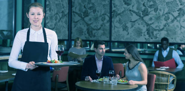 istock Polite waitress holding tray with dishes 1143235995