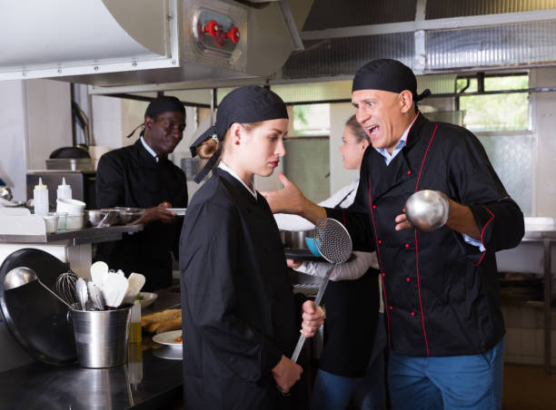 istock Exasperated chef scolding female employee 1143236144