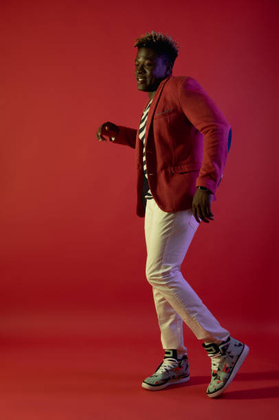 istock Cheerful man is dancing on red background 1143237517