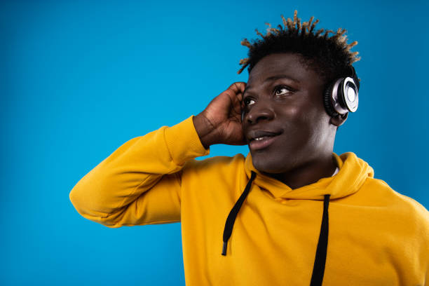 istock Handsome guy enjoying music on blue background 1143237544