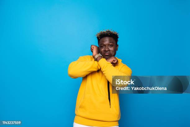 Fröhlicher Kerl Posiert Auf Blauem Hintergrund Stockfoto und mehr Bilder von Afrikanischer Abstammung - Afrikanischer Abstammung, Afro-amerikanischer Herkunft, Arm - Anatomiebegriff