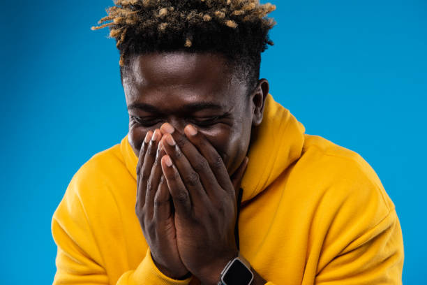 istock Young man is laughing and hiding face under arms 1143237603